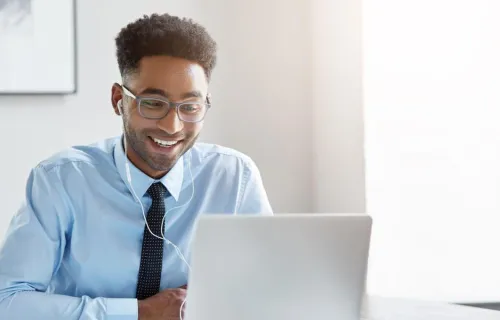 Young professional smiling at laptop