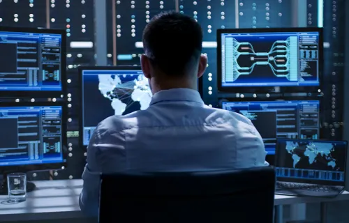 Cyber security professional looking at computer screens 