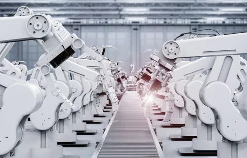 Vita robotarmar på rader inne i en industrilokal
