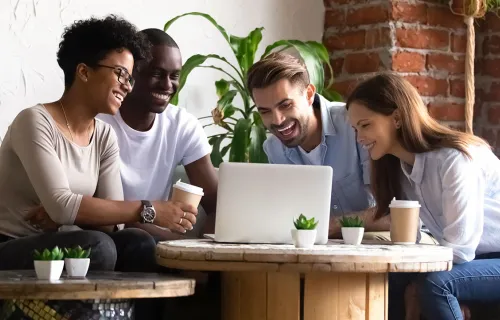 Group of casual diverse people laughing over a laptop