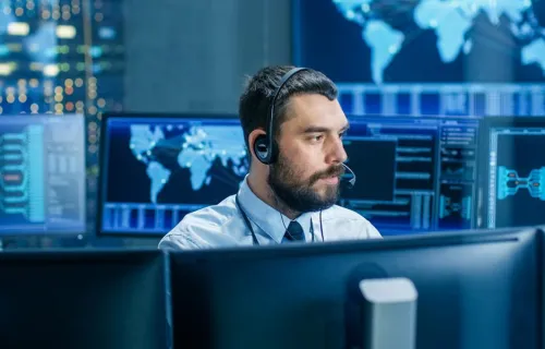 consultant in headset looking at monitor in control room