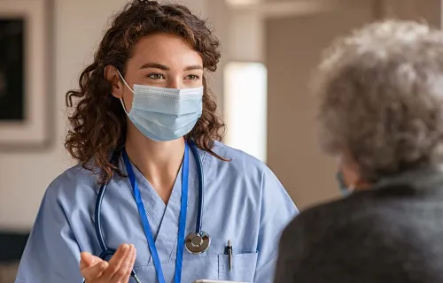 Masked nurse facing patient