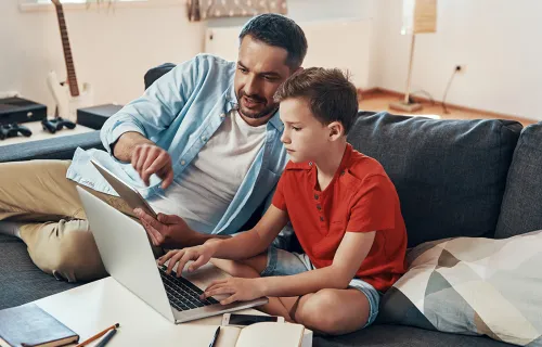 Dad teaches his son with Laptop