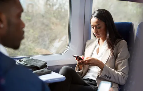 business woman on rail watching her mobile app