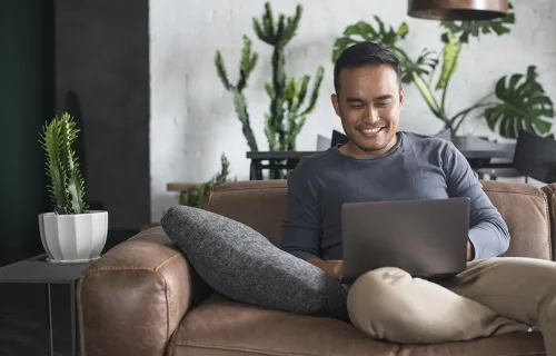 Man sitting with laptop, smiling