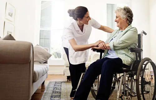 health care worker comforting elderly patient in wheelchair