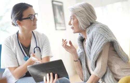 healthcare professional talking to an elderly patient