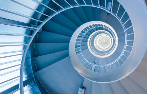 Looking up through a modern blue spiral staircase