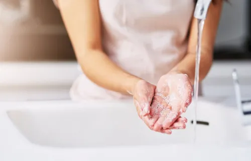 Tap water running over a person’s hands