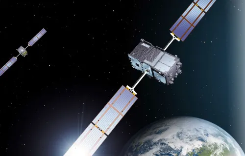 Två satelliter syns i den mörka rymden och nedanför ses jorden