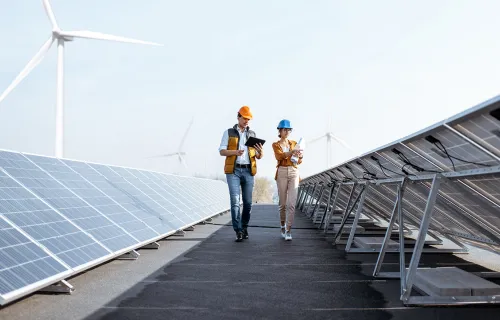 2 ouvriers marchant entre des panneaux solaires