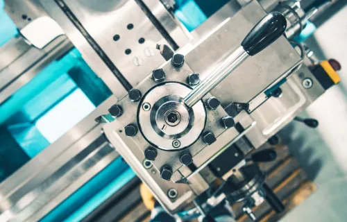 Detailaufnahme einer Fertigungsmaschine mit mechanischen Bauteilen.