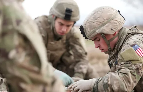Military medical personnel treating a soldier in the field