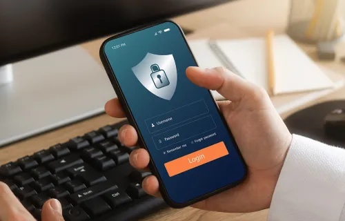 Hand hält ein Iphone auf dem ein Login zu sehen ist