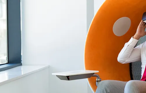 Person in VR headset in orange and white chair
