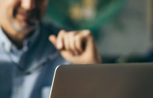 personne prenant un café en travaillant sur un ordinateur portable