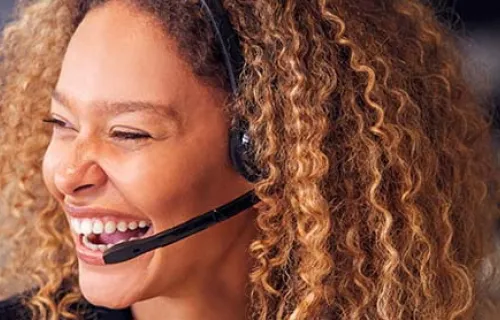 smiling female contact centre employee wearing a headset