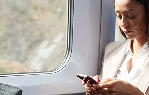 business woman on rail watching her mobile app