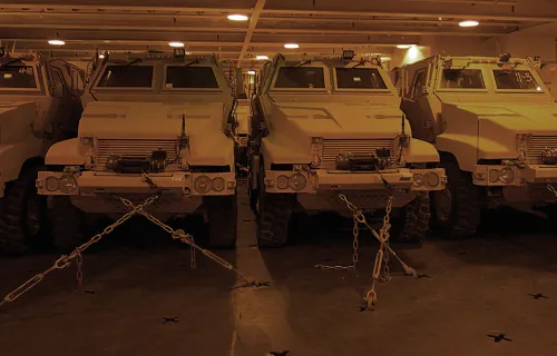 A row of military trucks secured on an aircraft carrier