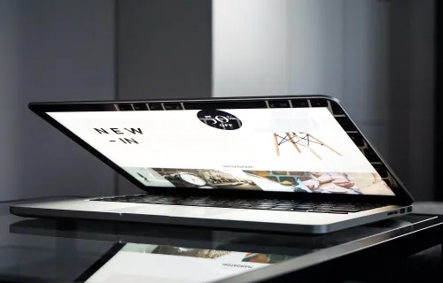 En laptop står halvt uppfälld och på skärmen syns en online shopping-sida