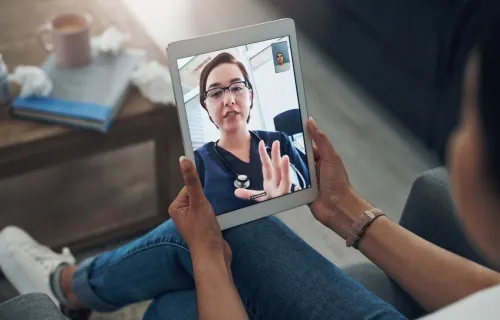 Patient video calls doctors on tablet device
