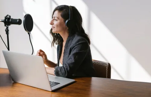 Person wearing headphones speaking into microphone