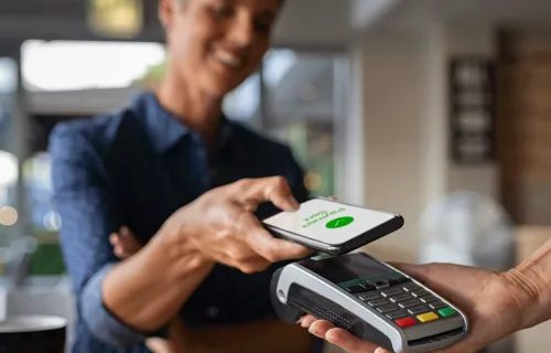 Person paying for purchase via contactless mobile phone payment hero