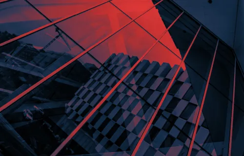 Close up of glass building reflecting red sky 