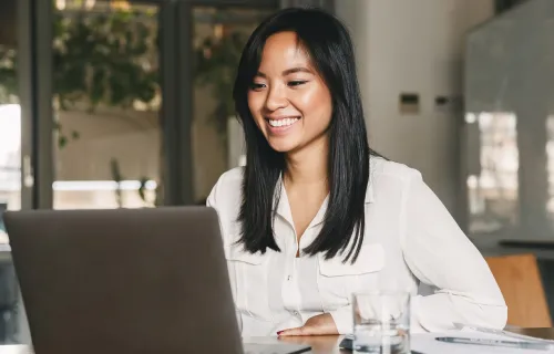personne souriante en travaillant sur un ordinateur portable
