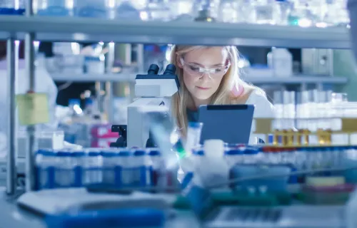 Researcher working in a lab using a tablet