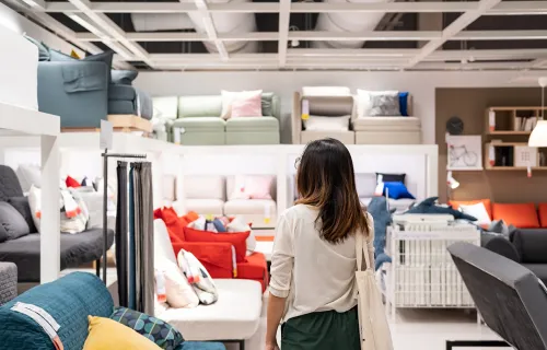 Kvinne ser på utstilte sofaer i en møbelbutikk
