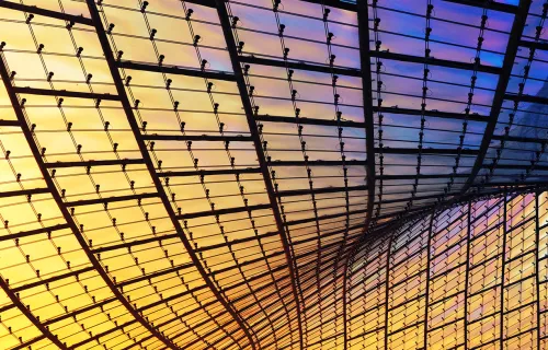 Glasskonstruksjon med rutemønster i gule og lilla toner.