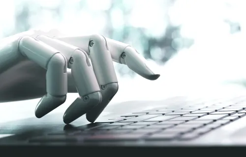 Robot hand typing on keyboard