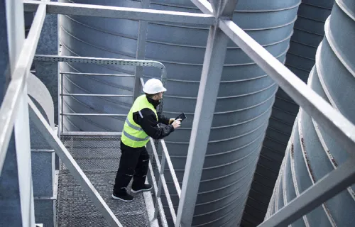 Worker in safety gear on high rise scaffolding