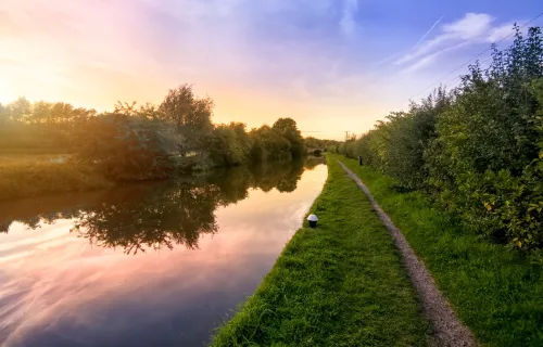 A serene view of a canal at sunset