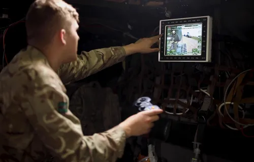 Soldier using a control looking at a screen 