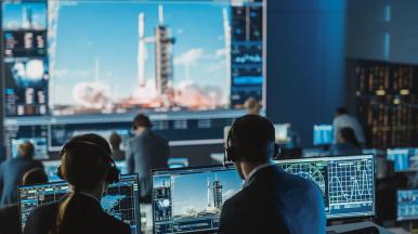 a mission control team observes a rocket launch, representing CGI’s space solutions