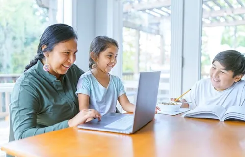 A person and a child looking at a computer