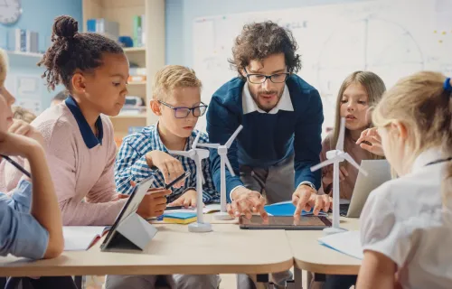 Teacher showing children model wind turbines