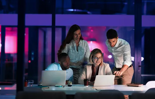 Tiimi katsomassa asiaa yhdessä tietokoneelta