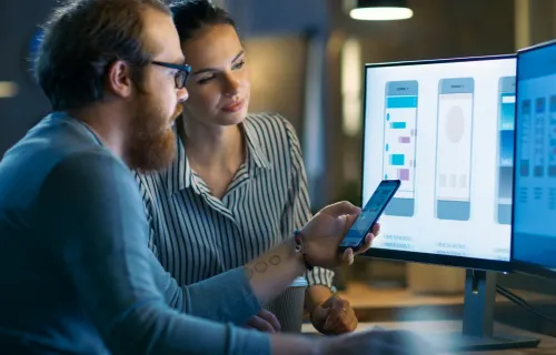 Zwei Tester schauen gemeinsam auf einen Bildschirm