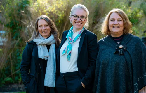 Tre personer står ute og smiler – kundeansvarlig fra CGI og representanter fra Samfunnsviterne