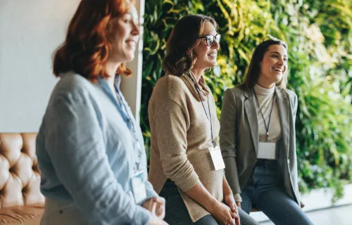 three women standing next to each other smiling