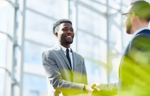 Two business men smiling while shaking hands
