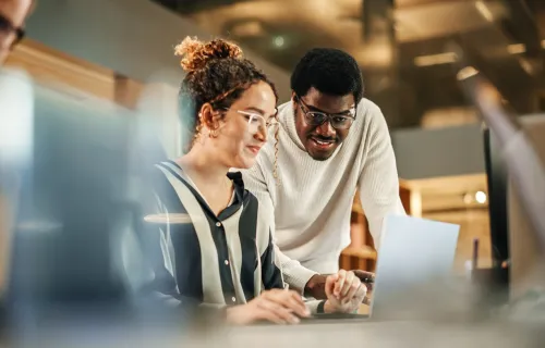 Two colleagues looking at a laptop