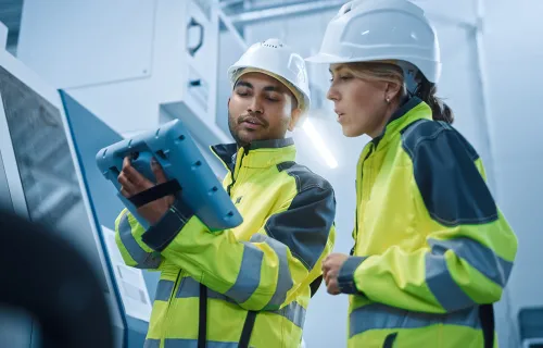 two utilities workers looking at a tablet