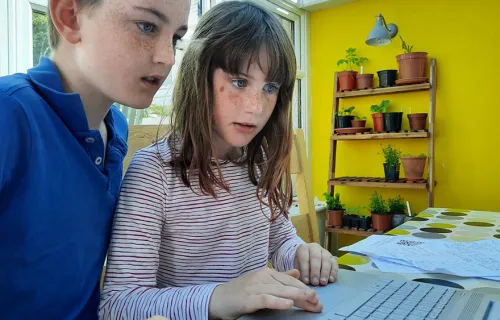 Children working on STEM activities on a laptop computer from home