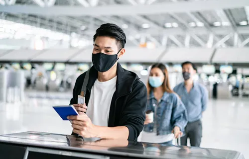 man in a mask holding a passport 