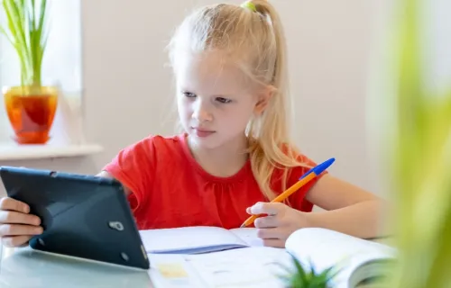 flicka gör hemläxan med hjälp av sin surfplatta