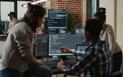 team working at a computer looking at code